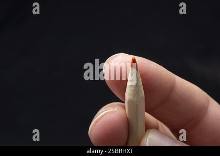 Hand holding a red colored pencil Stock Photo