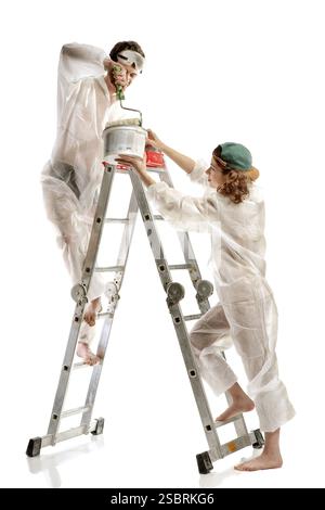 Attractive young adult couple painting interior wall of house Stock Photo
