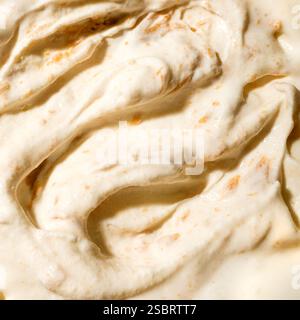 Salted caramel ice cream with pieces on brown sugar close up. Frozen yogurt with peanut butter texture. Stock Photo