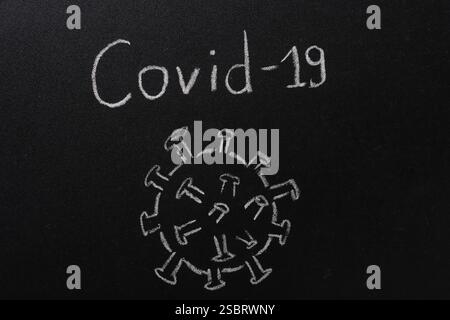 COVID-19 Words on a Black Chalk Board Stock Photo