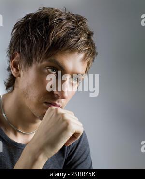Close-up portrait of a handsome guy, at gray background Stock Photo