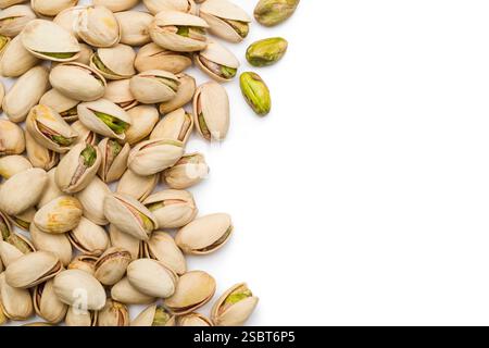Top view of pistachio nuts scattered on white background with copy space. Stock Photo