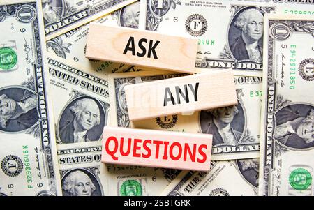 Ask any questions symbol. Concept words Ask any questions on beautiful wooden blocks. Dollar bills. Beautiful background from dollar bills. Business a Stock Photo