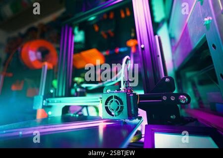 vibrant close-up 3D printer operating home workshop, advanced technology creative workspace. highlights details of the machine, illuminated by colorfu Stock Photo