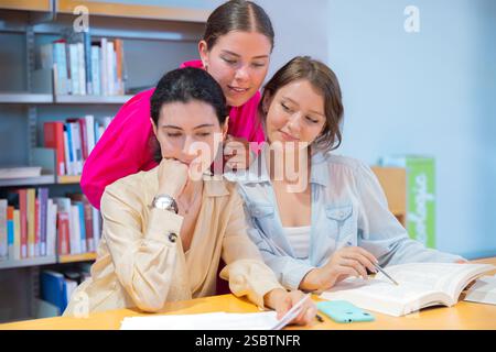 Three Young Women Studying Together in a Library Stock Photo