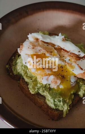 Avocado Toast with Fried Egg on a Plate Stock Photo