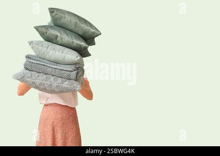 Woman with stack of pillows and folded warm plaid on light background Stock Photo