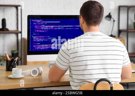 Male programmer working with computer in office, back view Stock Photo