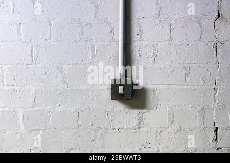 Lonely industrial light switch on white painted brick wall with texture Stock Photo
