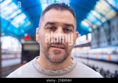 Thoughtful Man Looking Up at Train Station looking at camera Stock Photo