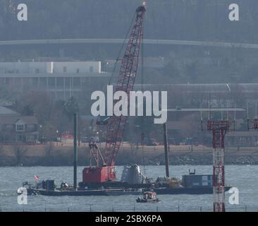 Parts of a plane are lifted from the water near the wreckage site in ...