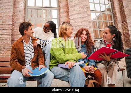 Cheerful Group of Diverse Students Engaged in Lively Conversation While Sharing Notes and Ideas. They Are Collaborating in a Fun and Interactive Study Session, Enjoying Their Time Together as Friends. High quality photo Stock Photo