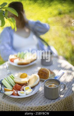 Close-up of a breakfast table with food outdoors in a natural setting Stock Photo