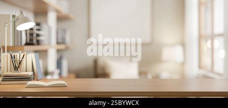 A copy space for displaying products on a wooden desk features a table lamp, books, and stationery with a blurred background of a living room. place o Stock Photo