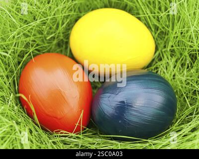 Three Multicolored Eastern Eggs In Fresh Green Grass Stock Photo