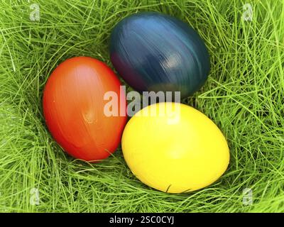 Three Multicolored Eastern Eggs In Fresh Green Grass Stock Photo