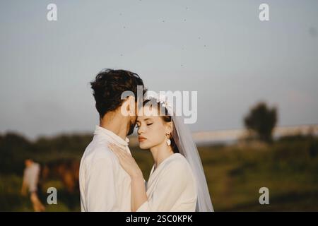 A bride and groom sharing an intimate moment in a tranquil natural setting Stock Photo