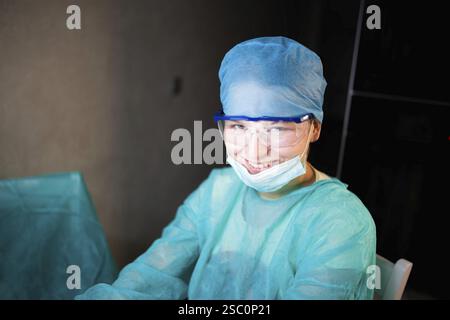 A smiling medical professional in blue protective clothing Stock Photo