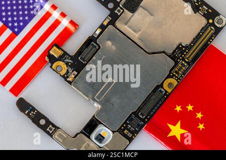 A semiconductors technology competition concept with micro chips and parts of a cellphone in between the American and Chinese national flag. Stock Photo