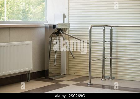 Turnstile security system for attendance control at the entrance to a public space closed by roller shutters. Stock Photo