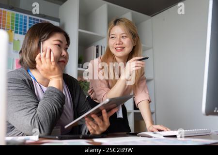 Creative design team collaborating on a project in a modern office space. Stock Photo