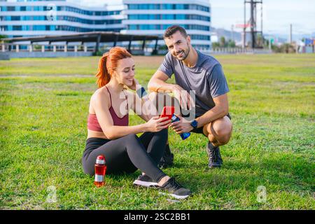 Young Fit Couple Relaxing After Workout in the Park Stock Photo