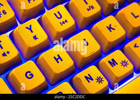 Bright yellow keyboard with blue light ambience Stock Photo