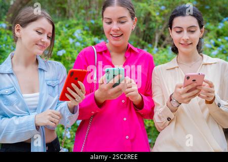 Happy Young Women Using Smartphones Outdoors Stock Photo