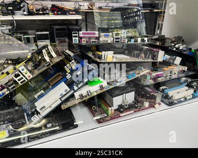 Kyiv, Ukraine - February 04, 2025: Stacked computer motherboards and electronic components in a technical or repair setting Stock Photo