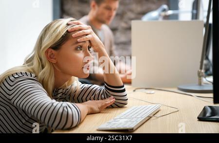 Portrait of a disappointed woman programmer looking stressed out while working on a computer code Stock Photo