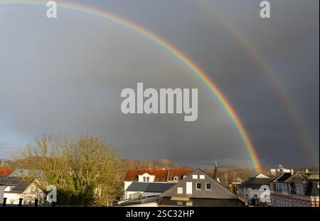 rainbow over the city with a dramatic gray rainy sky Stock Photo