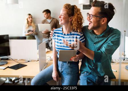 Two young businesspeople using a digital tablet while standing in a boardroom. Stock Photo