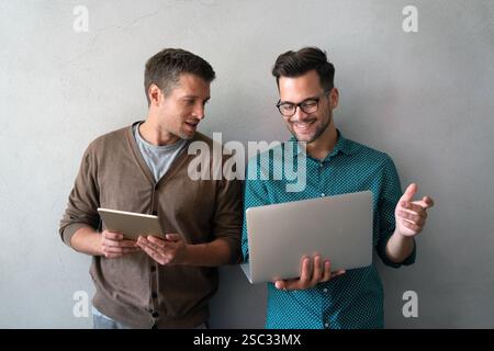 Happy business colleagues using a digital tablet, laptop in a boardroom. Working together as a team. Stock Photo