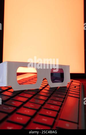 3D retro glasses on a keyboard with a red background. Stock Photo