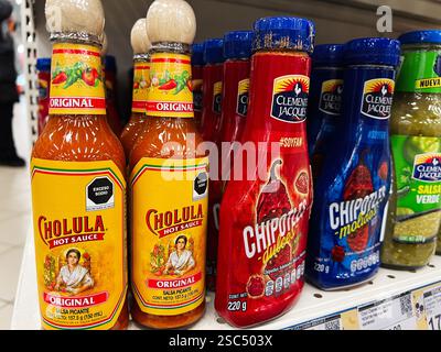 Kyiv, Ukraine - February 04, 2025: Various hot sauce bottles displayed on a shelf, offering diverse spicy condiment options. Stock Photo