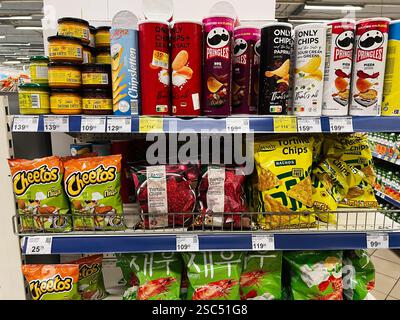Kyiv, Ukraine - February 04, 2025: Supermarket aisle with various snack products including chips, dips, and packaged goods Stock Photo