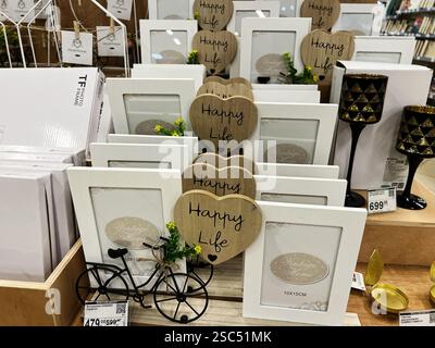 Kyiv, Ukraine - February 04, 2025: Decorative photo frames featuring 'Happy Life' text and vintage-themed accents, organized on shelves. Stock Photo
