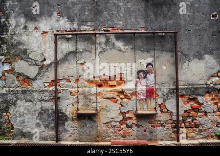 Brother and Sister on a Swing-World Famous street mural art work by Malaysian deaf mute artist Louis Gan,2012,Chulia street,Georgetown,Penang,Malaysia Stock Photo