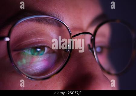 woman in glasses looking at monitor screen in glasses on glass reflection Stock Photo