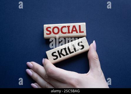 Social skills symbol. Wooden blocks with words Social skills Beautiful deep blue background. Businessman hand. Business and Social skills concept. Cop Stock Photo