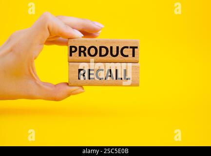 Product recall symbol. Concept words Product recall on wooden blocks. Beautiful yellow background. Businessman hand. Business and Product recall conce Stock Photo
