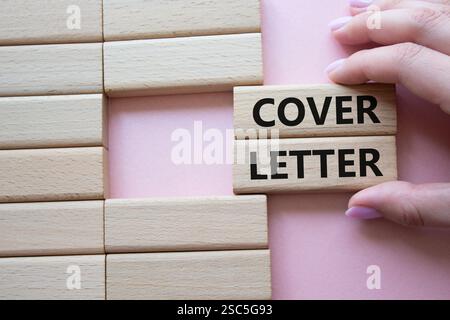 Cover Letter symbol. Concept word Cover Letter on wooden blocks. Businessman hand. Beautiful pink background. Business and Cover Letter concept. Copy Stock Photo