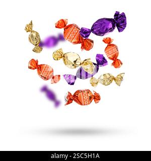 Candies in bright wrappers falling on white background Stock Photo