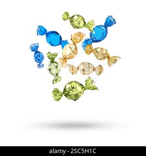 Candies in bright wrappers falling on white background Stock Photo