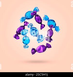 Candies in bright wrappers falling on pink background Stock Photo