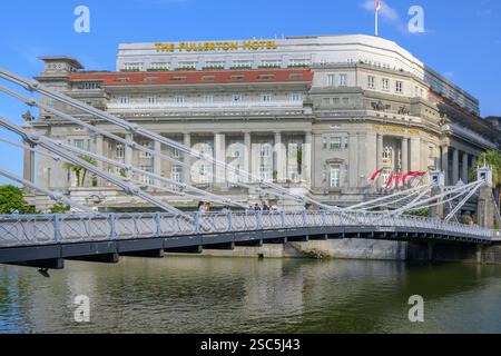 The historic (1869) Cavanagh Bridge over the Singapore River with the Fullerton Hotel (former central post office) in the background Stock Photo