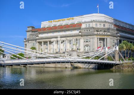 The historic (1869) Cavanagh Bridge over the Singapore River with the Fullerton Hotel (former central post office) in the background Stock Photo