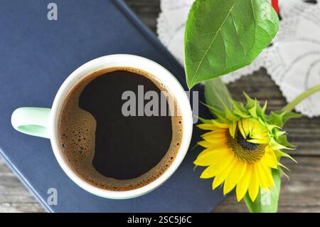 Top view of cup of coffee, book and sunflower Stock Photo
