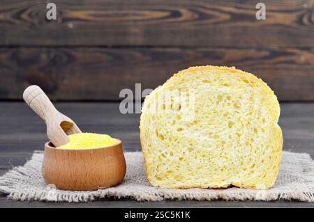 Sliced corn bread and corn flour in wooden bowl Stock Photo