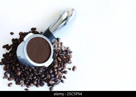 Ground coffee in the filter holder and coffee beans isolated on a white background. Directly above. Copy space. Stock Photo
